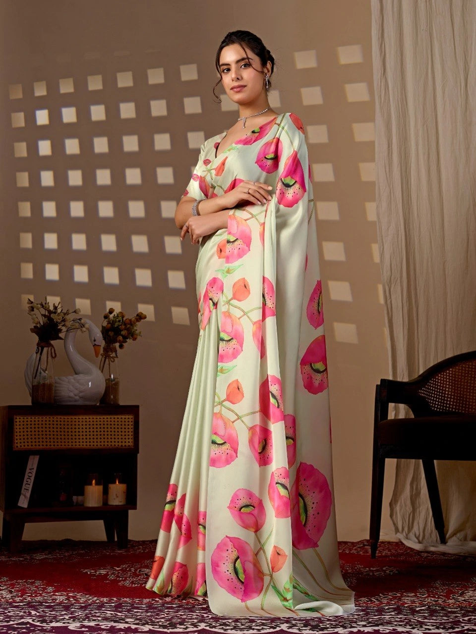 Woman wearing a floral saree standing in a room with decorative elements.