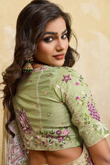 Woman wearing a green embroidered blouse with floral patterns on a beige background