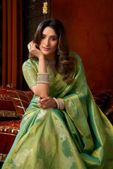 Woman in a green saree with jewelry against a warm-toned background