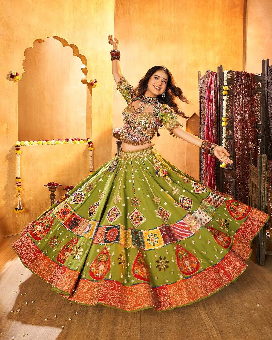 Woman in traditional green and red embroidered outfit dancing in a decorated room.