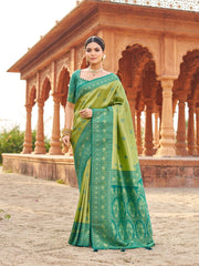 Woman in a green saree standing in front of an architectural structure.