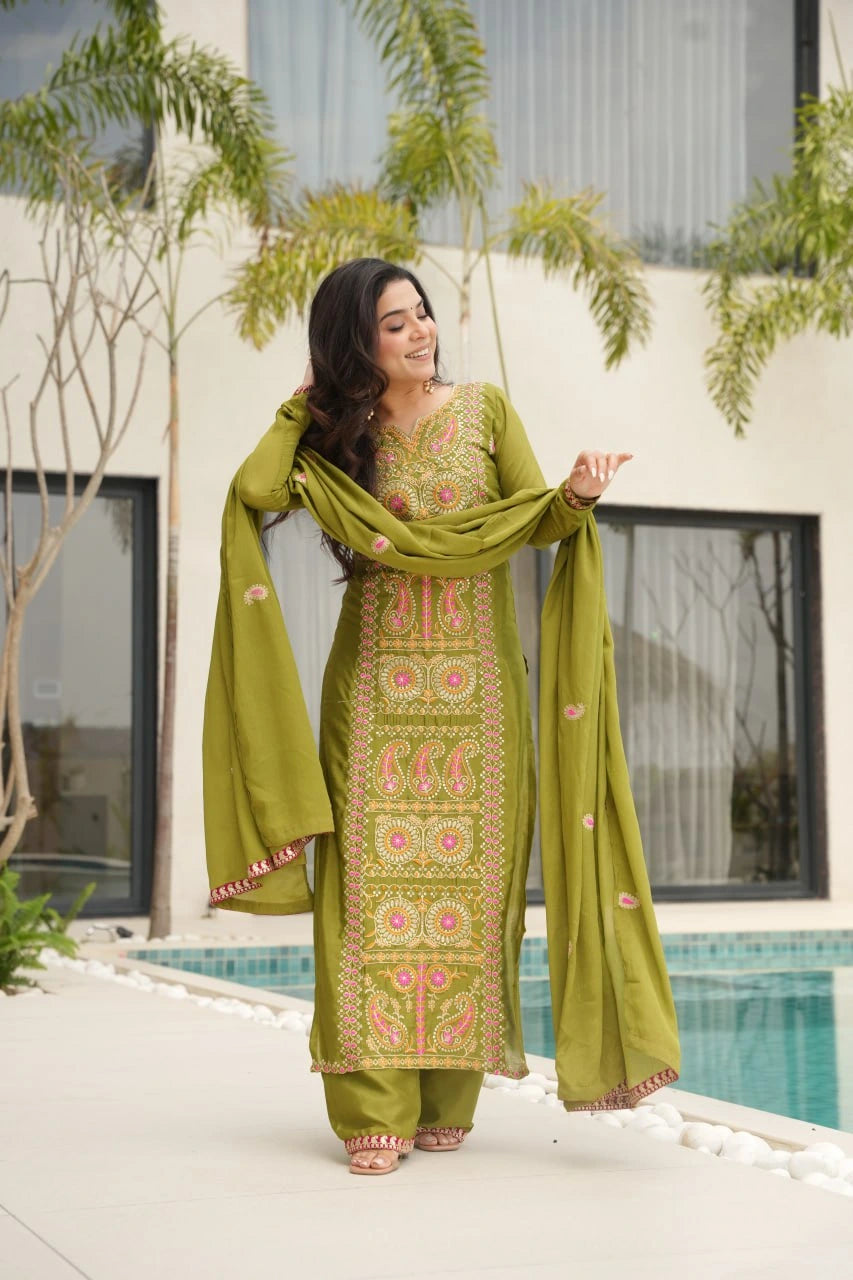 Woman in a green traditional outfit standing by a poolside.
