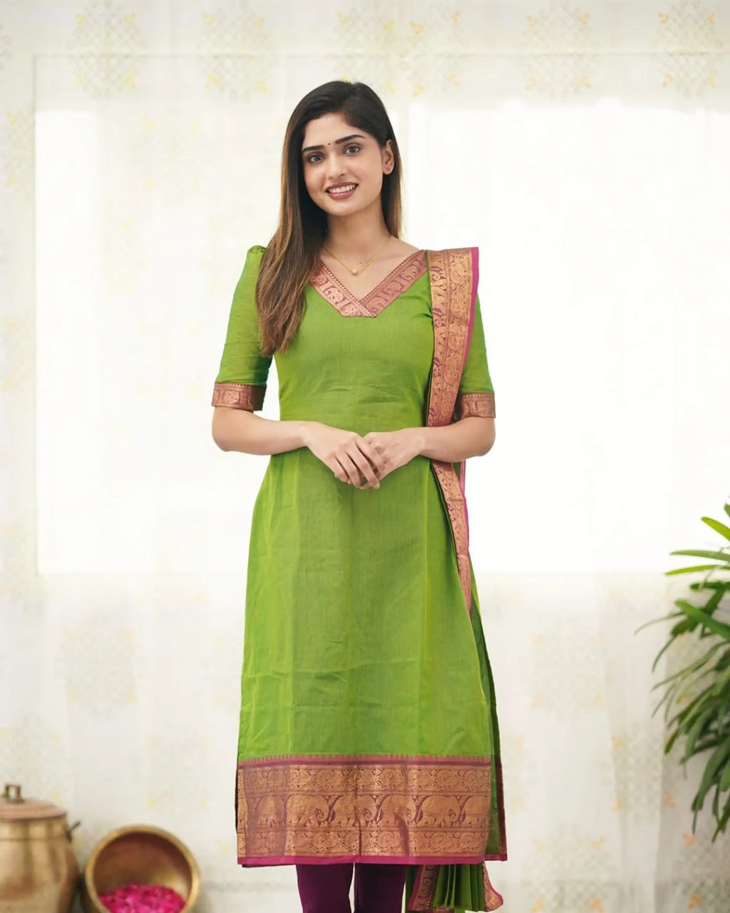 Woman wearing a green traditional outfit with a white background