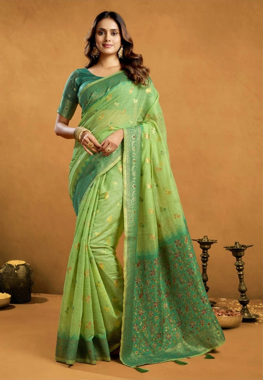 Woman wearing a green saree with a subtle pattern on a brown background