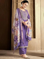Woman wearing a purple traditional outfit with a floral dupatta in a room.