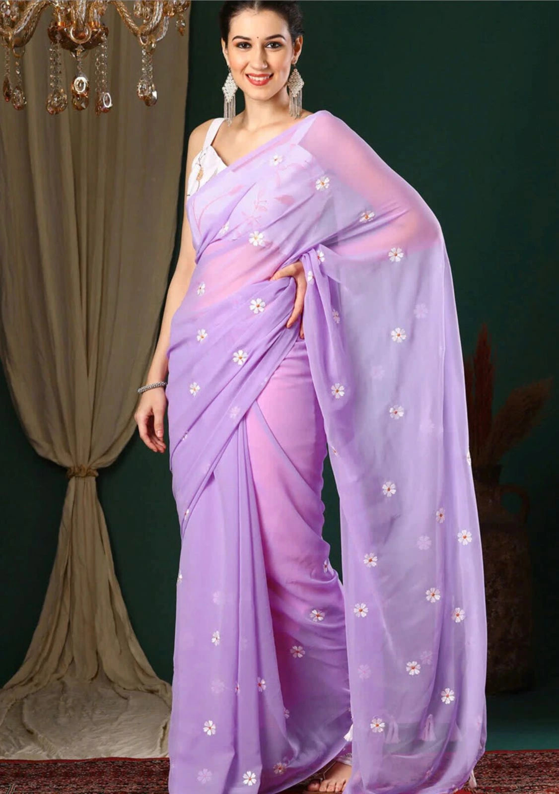 Woman wearing a lavender saree with white floral patterns against a dark background