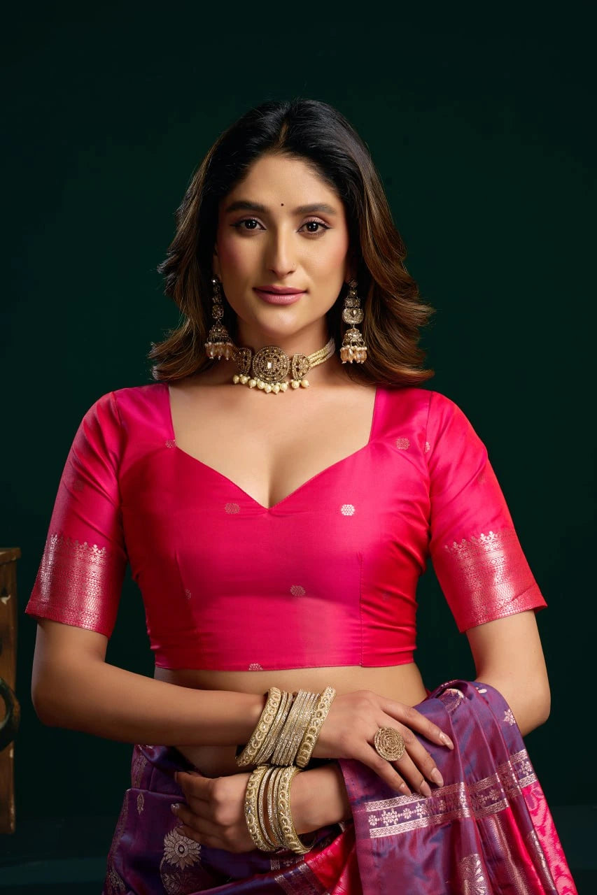 Woman in a pink traditional outfit with gold jewelry against a dark background