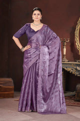 Woman wearing a purple saree with a dark background