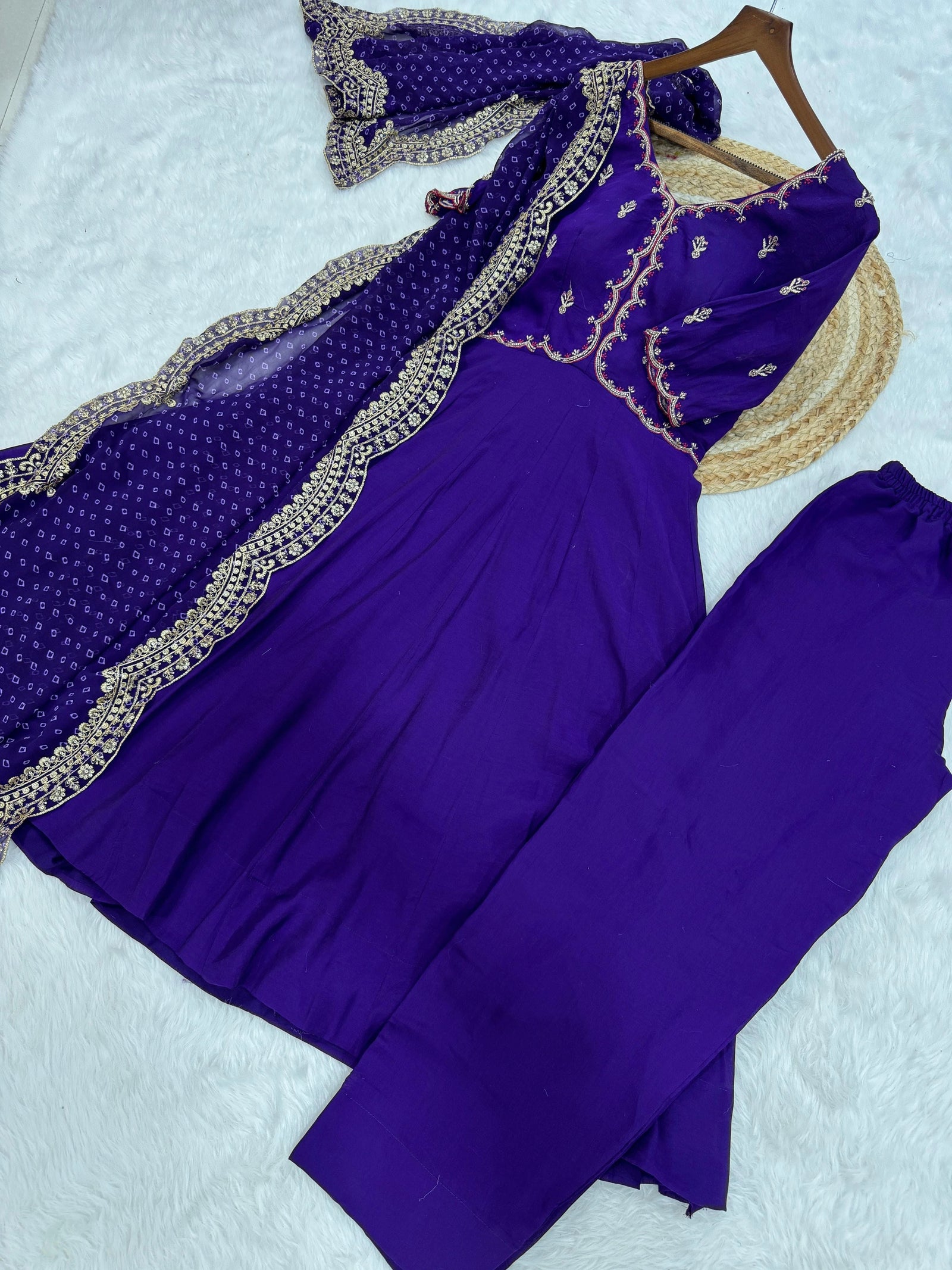 Purple traditional outfit with embroidered details on a light gray background