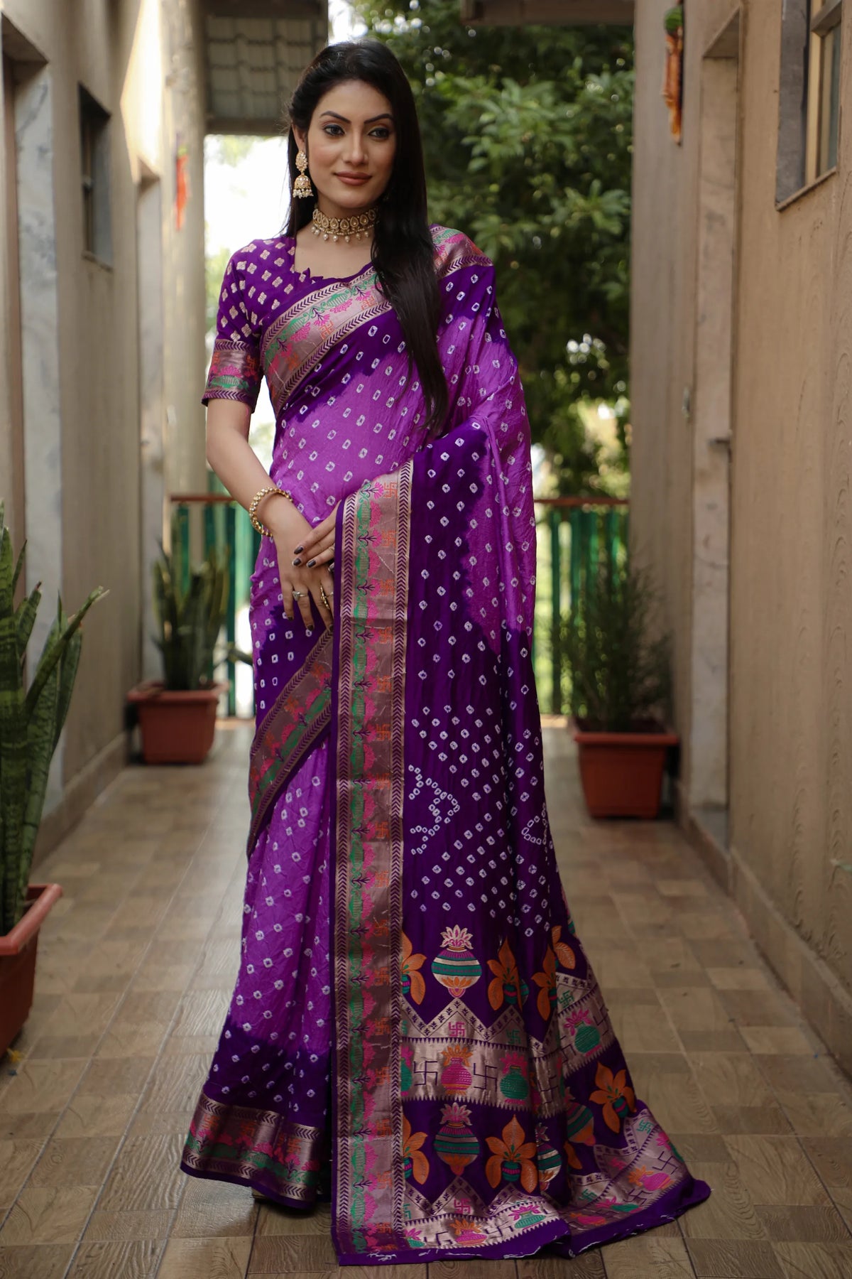 Woman wearing a purple saree with a pattern in an outdoor setting
