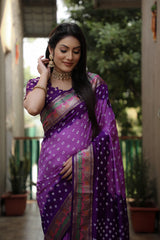 Woman in a purple saree with a blurred outdoor background