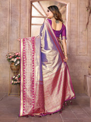 Woman holding a traditional saree with intricate patterns in a decorative setting.