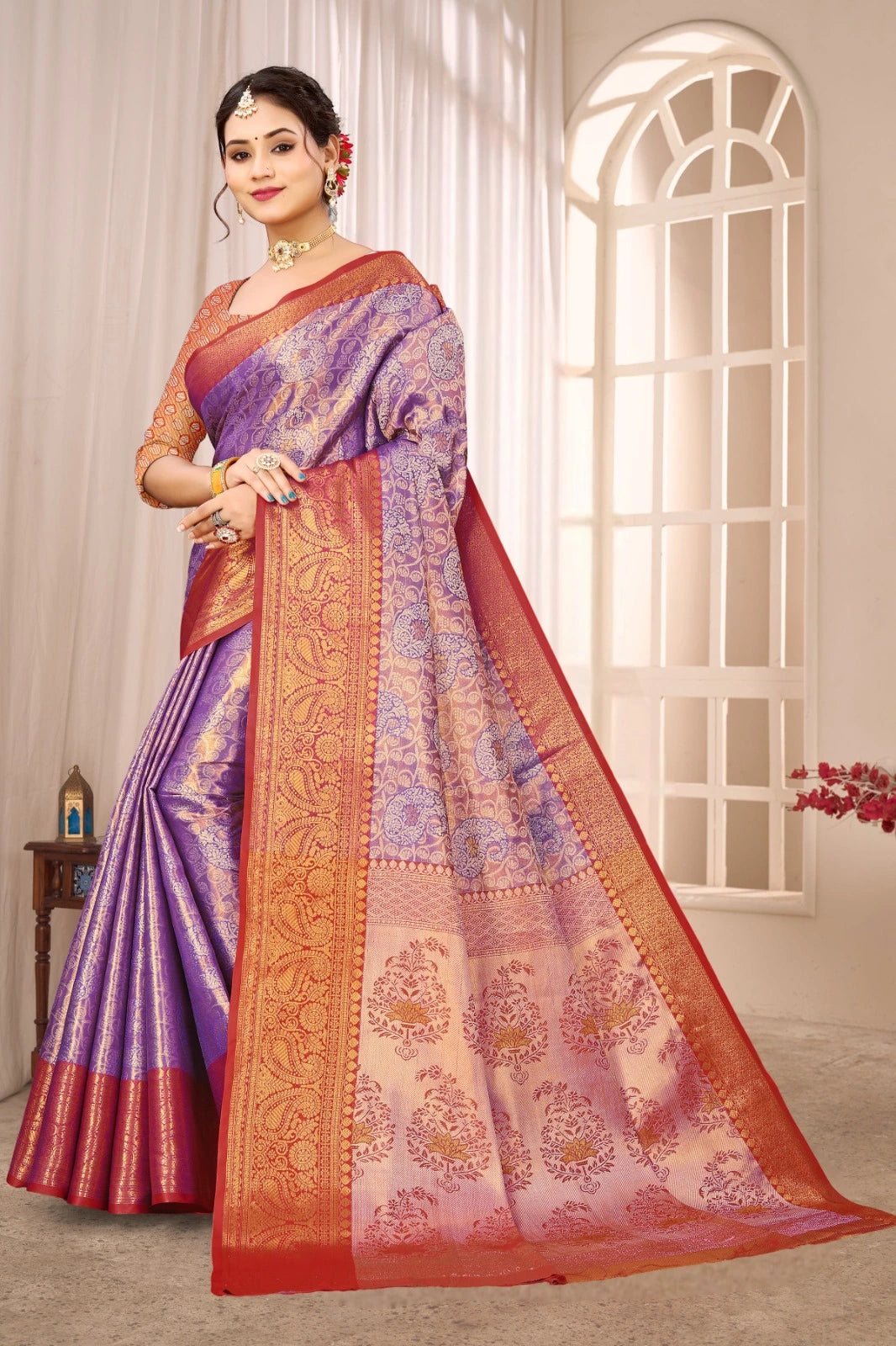 Woman wearing a traditional saree with a purple and orange design in a well-lit room.