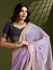 Woman wearing a traditional saree with a dark blouse against a neutral background