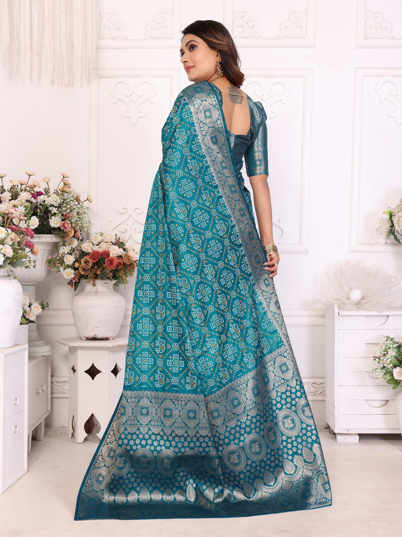 Woman wearing a teal saree with a white background