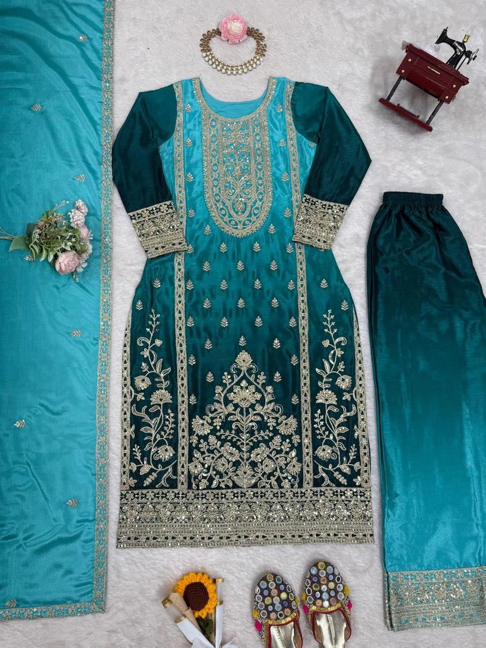 Teal embroidered outfit with matching pants on a light gray background