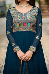 Navy blue traditional outfit with colorful embroidery on a blurred outdoor background