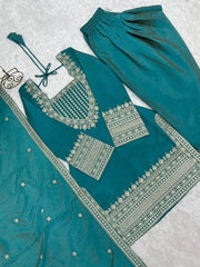 Teal traditional outfit with intricate silver embroidery on a light gray background