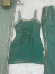 Teal outfit with lace-up front and decorative elements on a textured white background