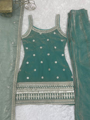 Green embroidered outfit with silver details on a textured surface