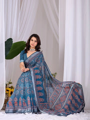 Woman wearing a blue saree with a white curtain background