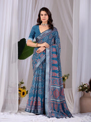 Woman wearing a blue saree with a white curtain background