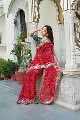 Model in Red Gota Patti Saree seated against carved palace column