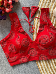 Red bikini set with intricate patterns on a textured surface