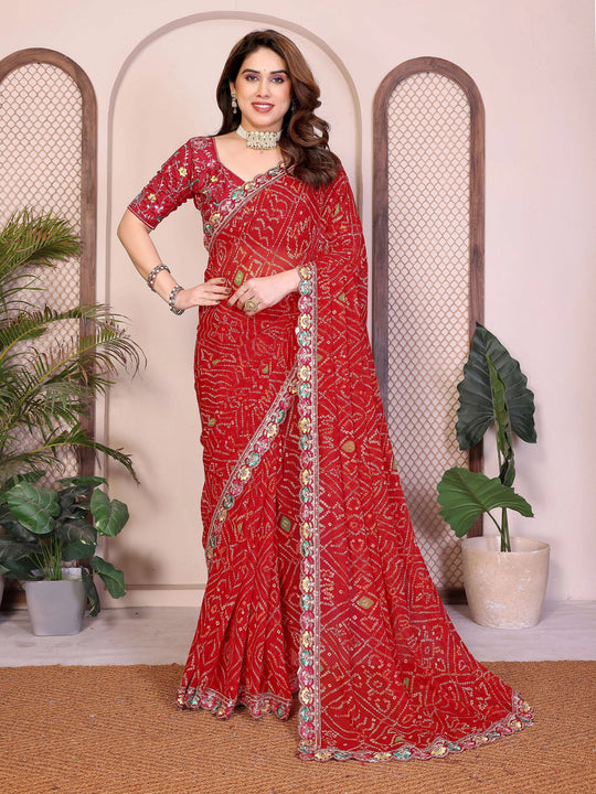 Woman wearing a red saree with intricate patterns in a decorative setting.