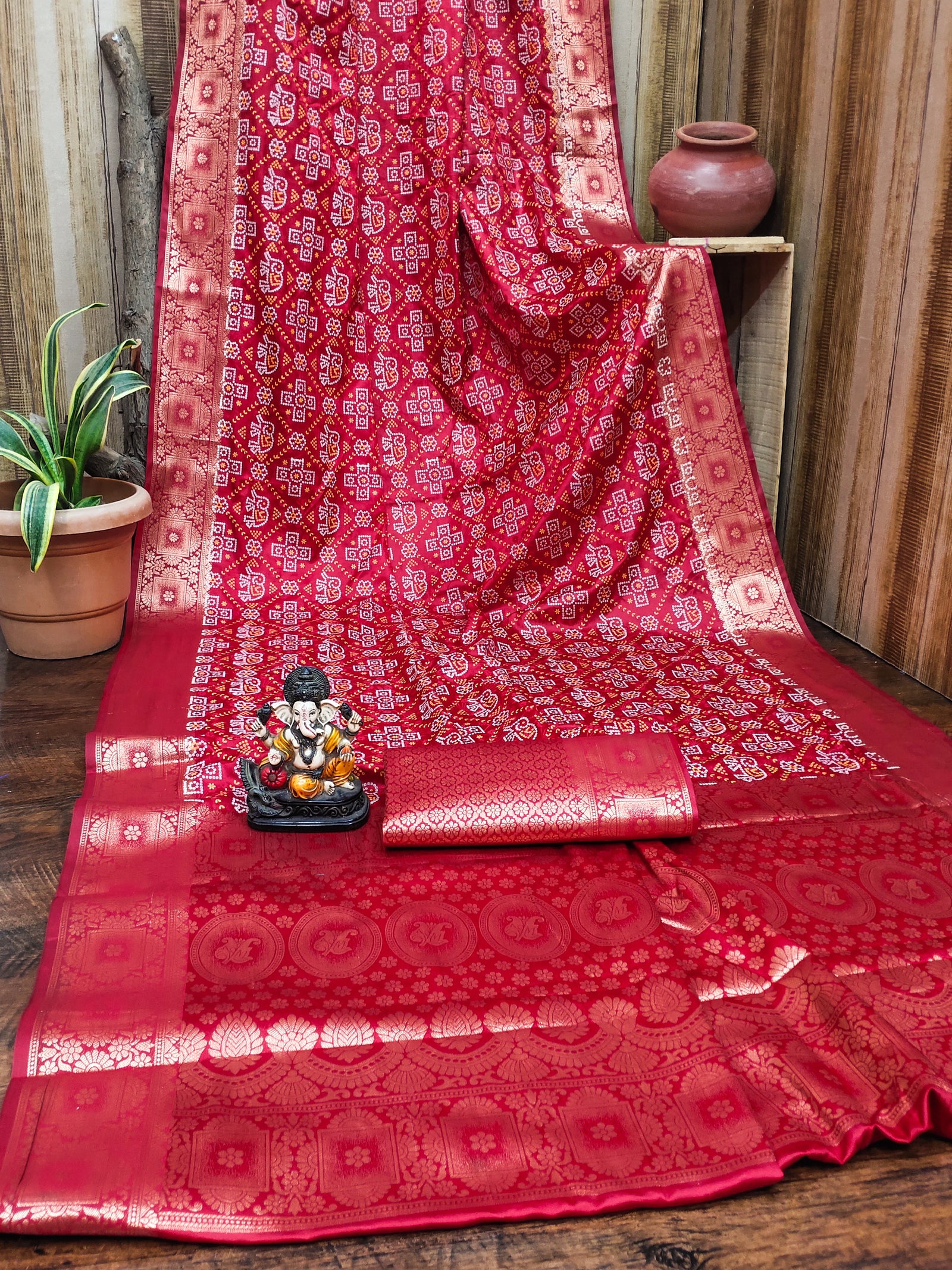 Red patterned fabric with a small statue on a wooden surface