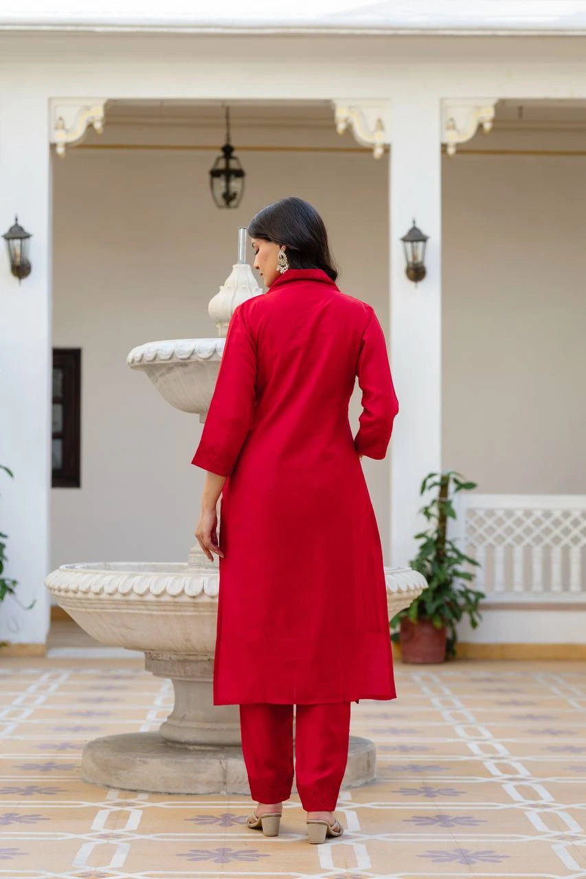 Person wearing a red outfit standing in a decorative indoor setting.