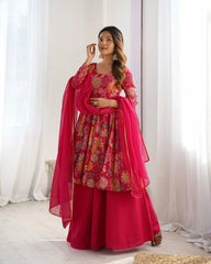 Woman in a vibrant red traditional outfit with floral patterns against a white curtain background