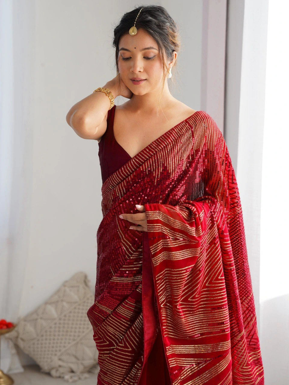 Woman wearing a red saree with a white background