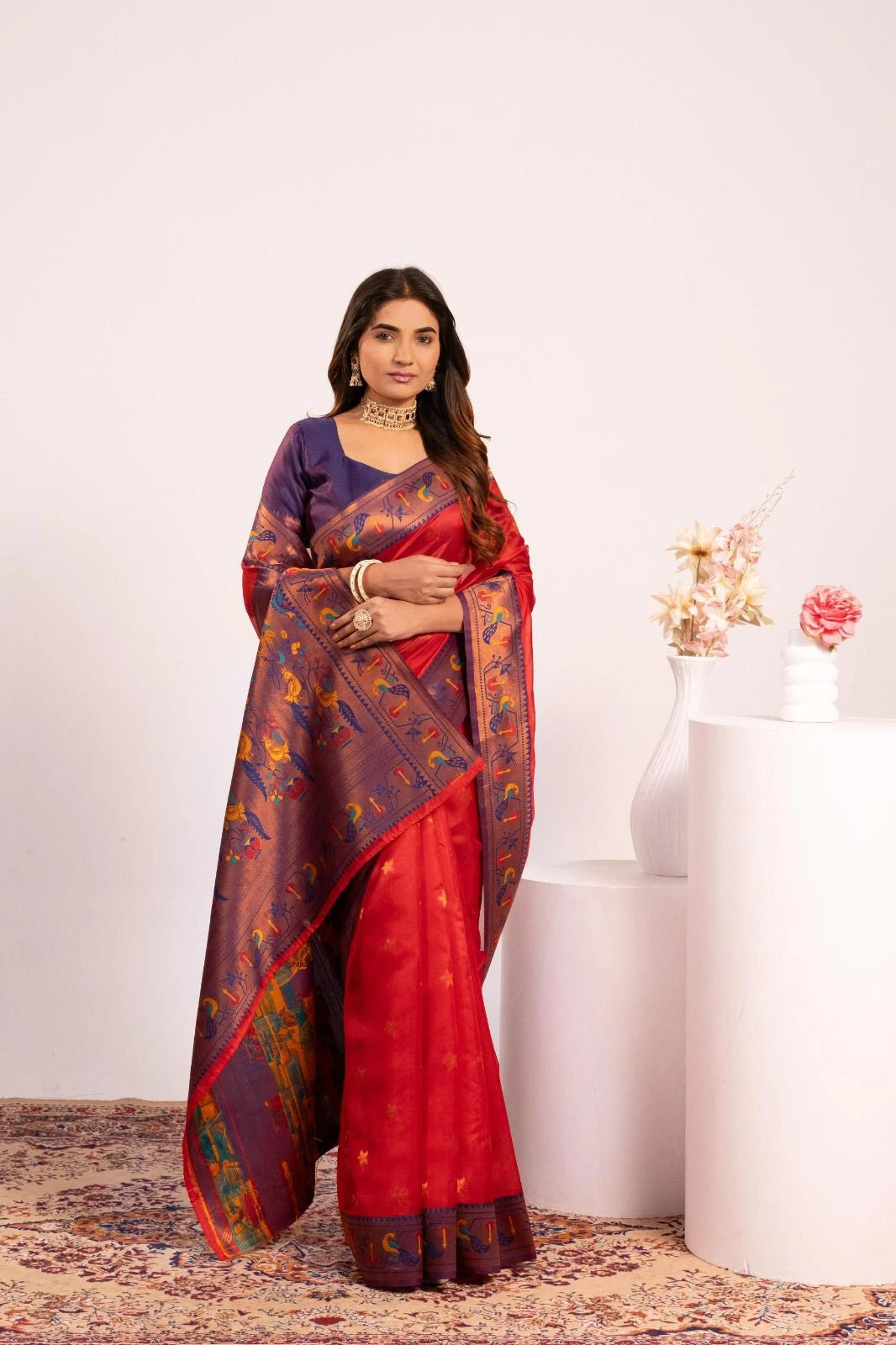 Woman wearing a red and blue saree with a white background