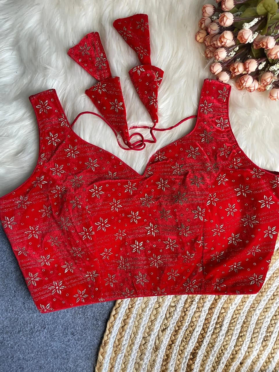 Red patterned bralette with matching underwear on a textured surface.