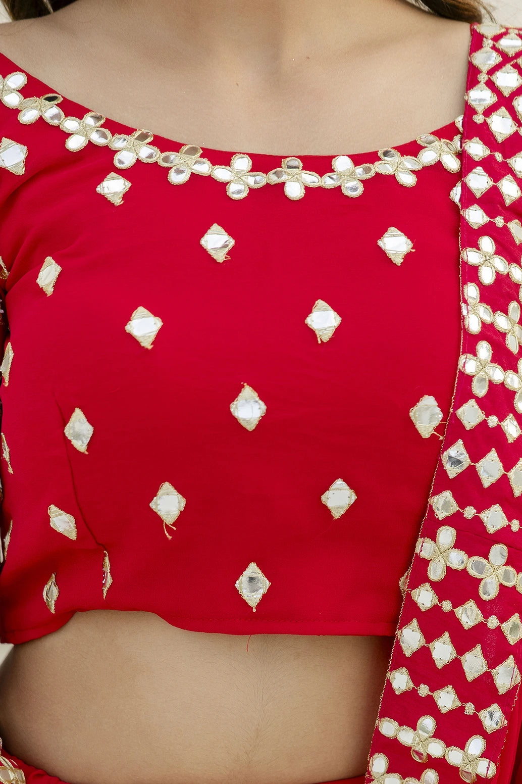 Red blouse with white diamond patterns and embellishments