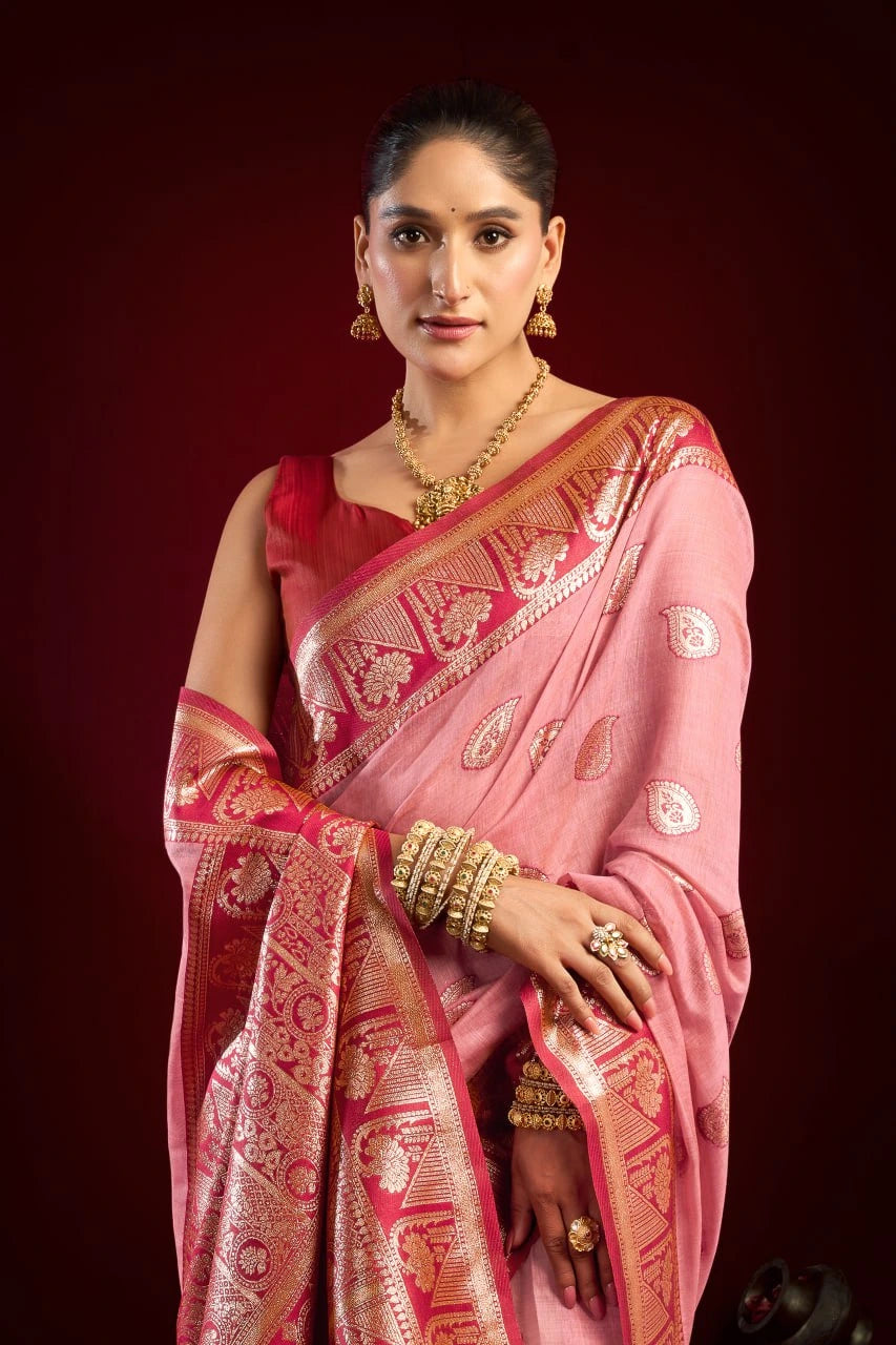 Woman in a pink saree with gold patterns on a red background
