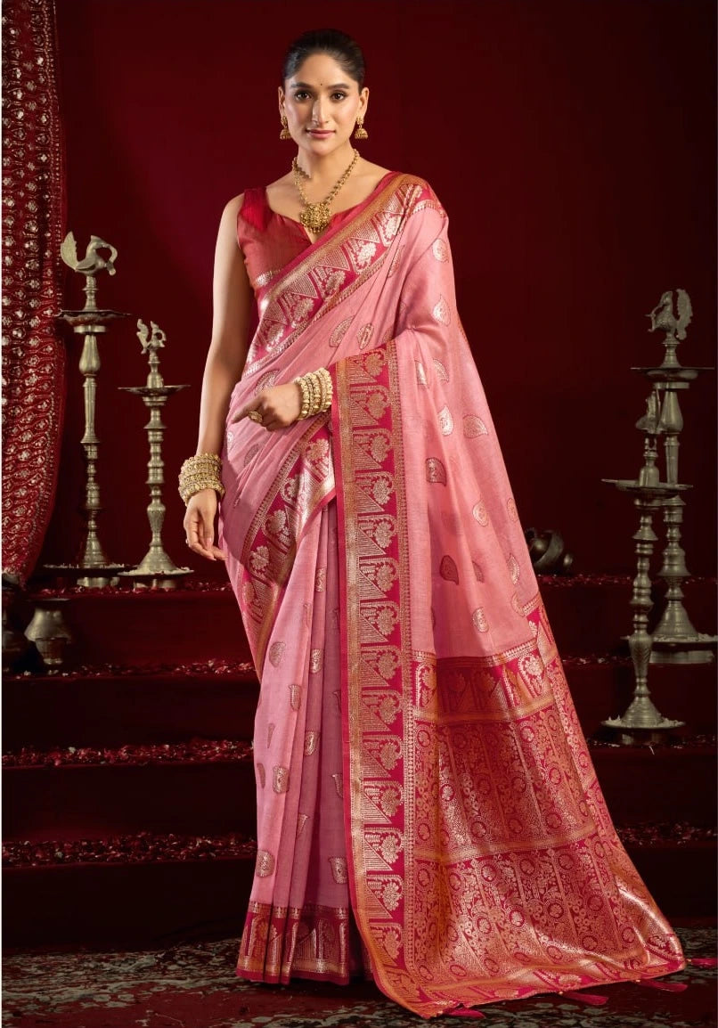 Woman wearing a pink saree with a red blouse against a dark background