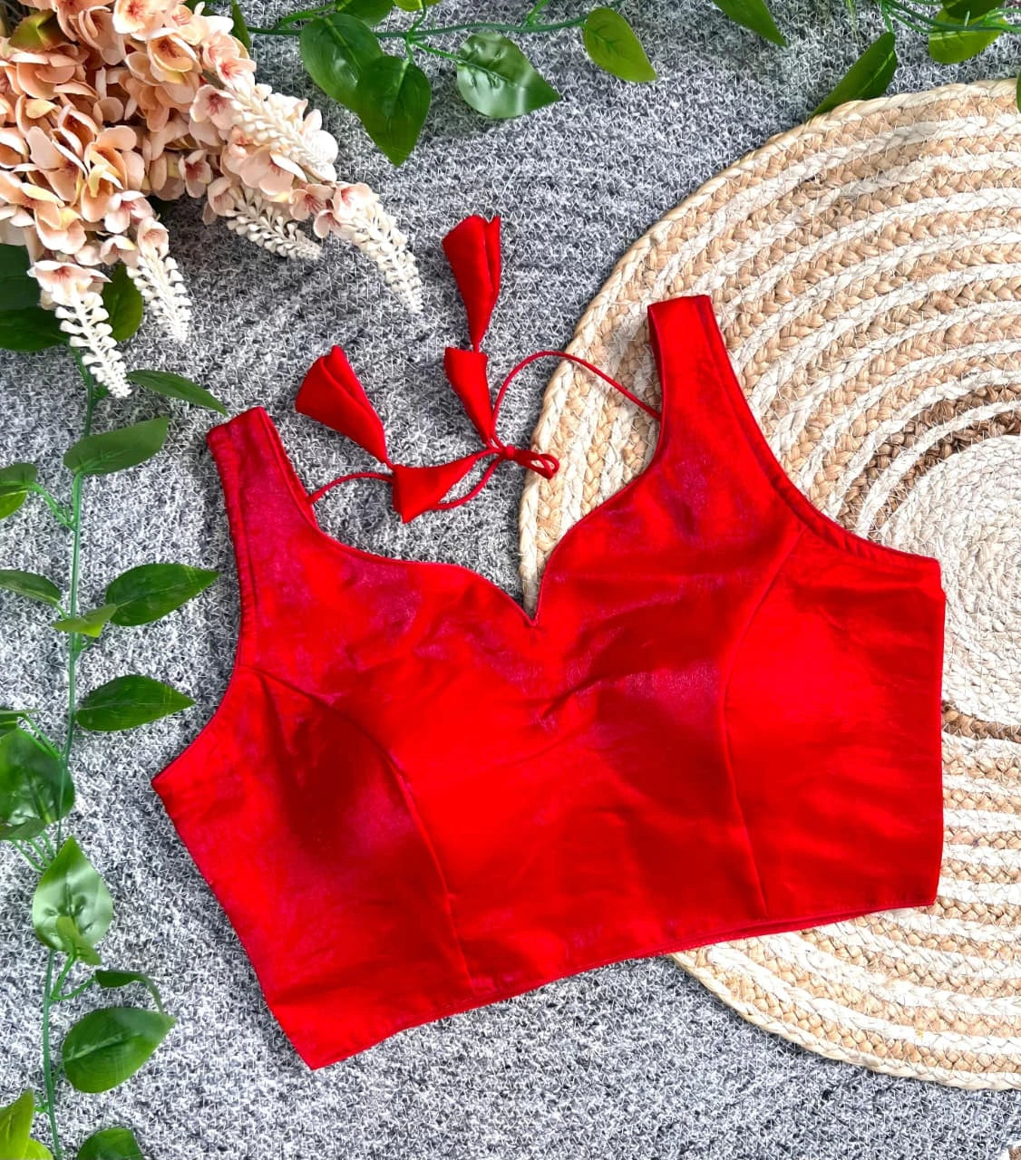 Red bikini top on a textured surface with decorative elements