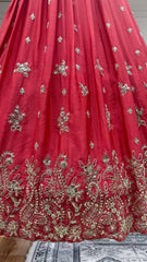 Red fabric with gold embroidery on a wooden surface
