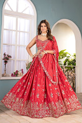 Woman in a red embroidered traditional dress standing in a well-lit room with plants.