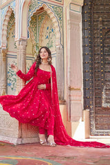 Woman in a red traditional outfit standing in front of an ornate architectural background