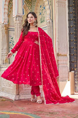 Woman in a red traditional outfit standing in front of an architectural background