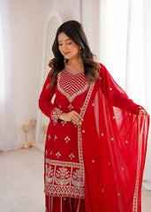 Woman wearing a red embroidered traditional outfit with a white background