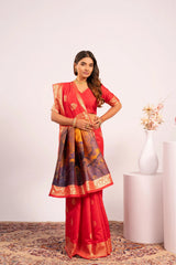Woman wearing a red saree with a patterned blouse against a white background
