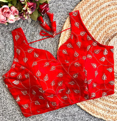 Red patterned top on a textured surface with flowers in the corner
