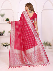 Woman wearing a red saree with white patterns in a white room.