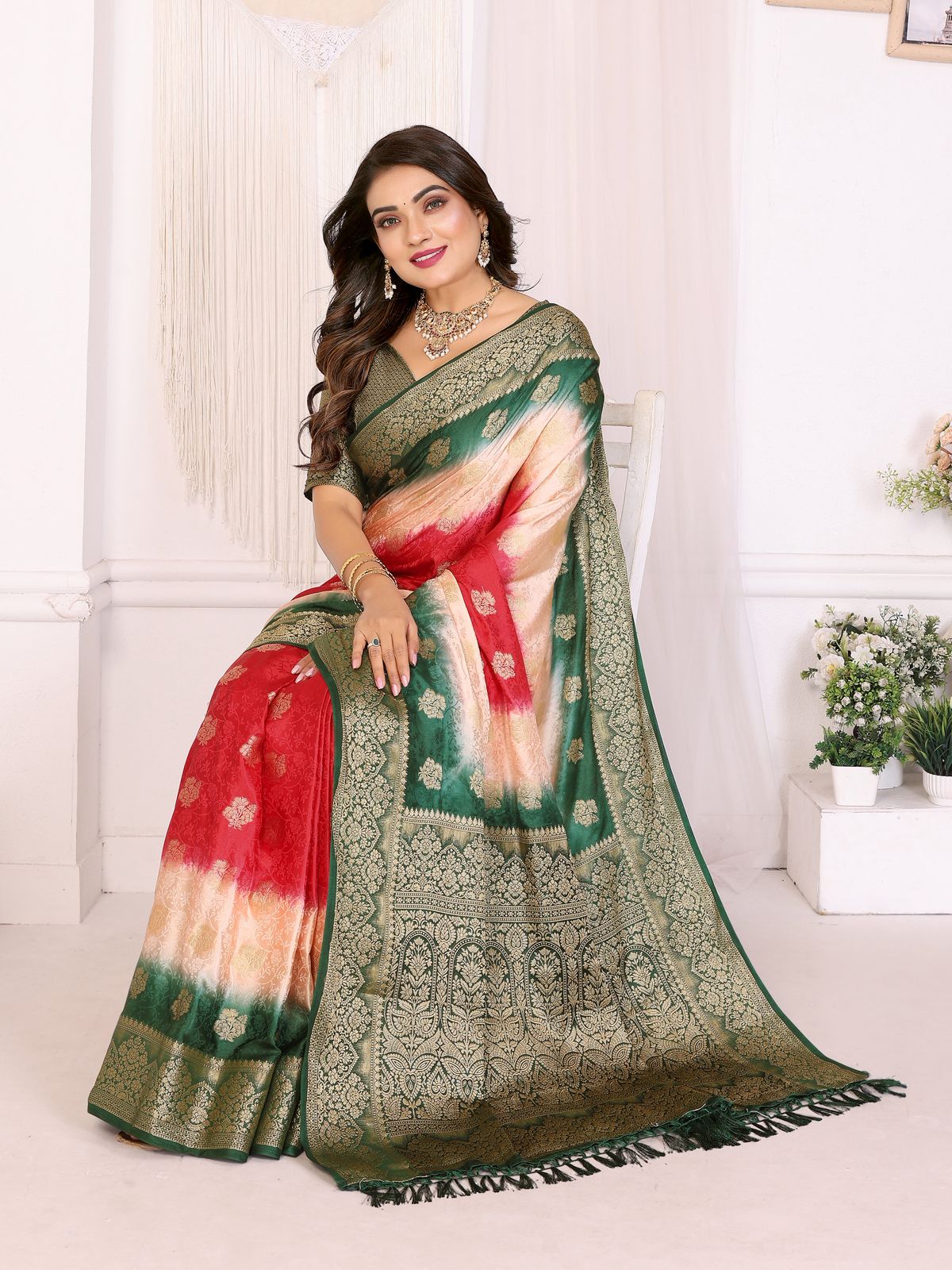 Woman wearing a traditional saree with a red and green pattern in a bright room.