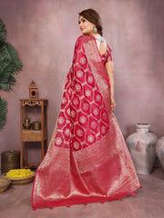 Woman wearing a red saree with white patterns in a room setting.