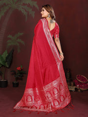 Woman wearing a red saree with intricate patterns against a dark background